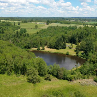 Paysage verdoyant et lac photographiée en vue aérienne par le drone Presta Div'Airs