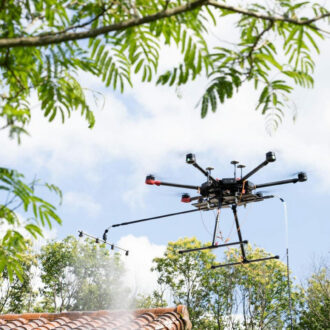 Le drone Presta Div'Airs en train de pulvériser le traitement pour démoussage d'une toiture en tuiles